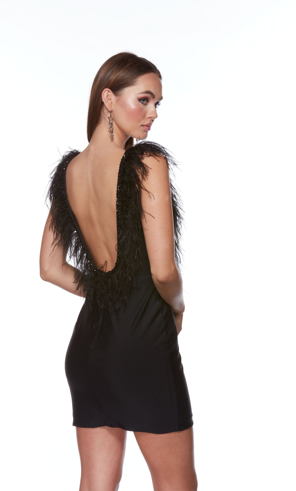 An elegant, short homecoming dress in classic black. The dress features a plunging neckline and a scooped open back trimmed with black stones and feathers. 
