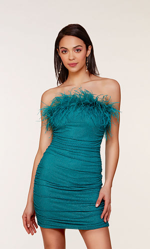 A stretch mesh strapless tube dress adorned with sparkly stones, ruching detail, and feather trim in the color lapis.