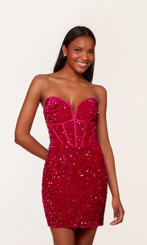 A short corset prom dress in iridescent, raspberry colored sequins. The dress features a strapless neckline, a zipper side slit, and a lace-up back.