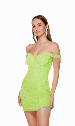 A show-stopping short formal dress made from a neon green-colored plush sequin fabric with sparkly fringe trim at the sleeves and left hemline. The dress has an off-the-shoulder neckline and a lace-up back style for a custom fit.