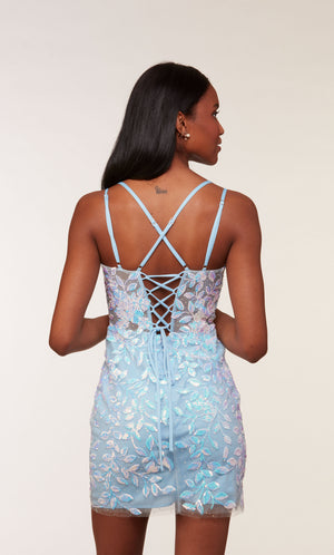 A light blue, fitted short designer dress with a lace-up back, a sheer bodice, and iridescent sequin embellished floral appliques throughout. 