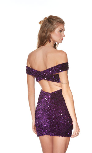 An off-the-shoulder, short formal dress made from a purple sequin fabric. The back of the dress has a thick stap criss cross closure.