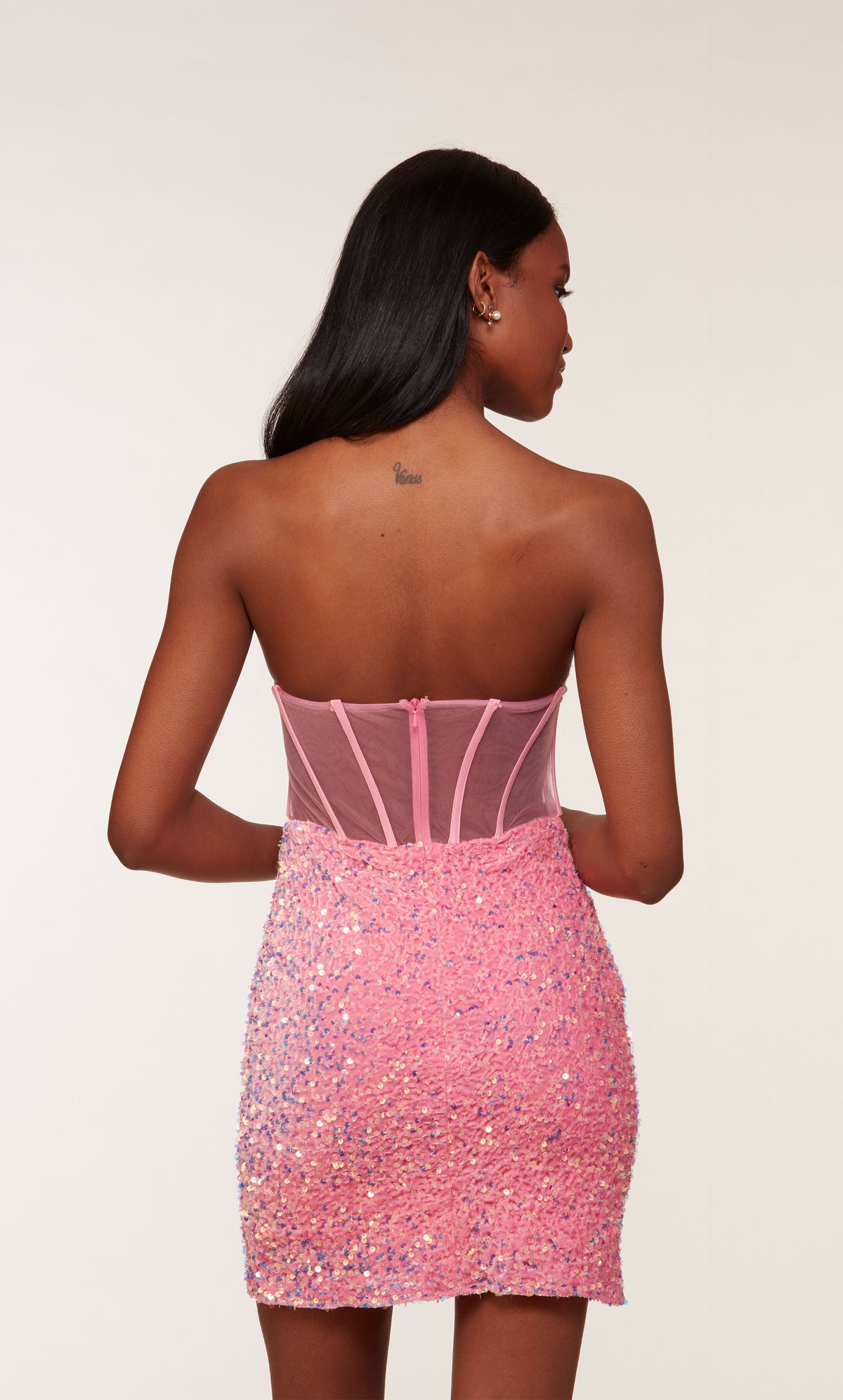 A glamorous corset top dress featuring a strapless zip-up back and sheer bodice, in bubblegum pink colored plush sequins.