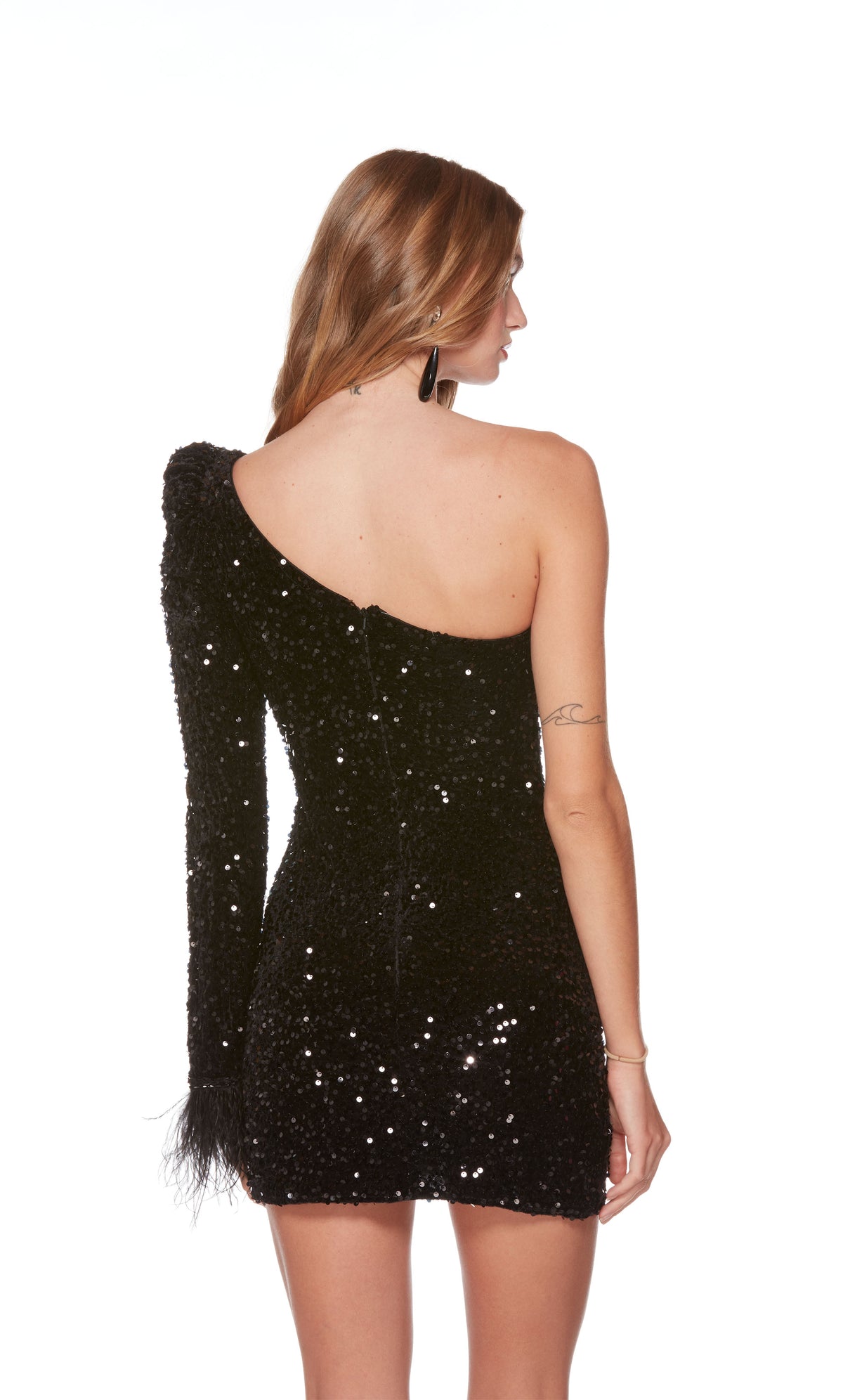 A chic, one-shoulder short designer dress highlighting a feather-trimmed sleeve and a zip-up back, in a sparkly black sequin fabric.