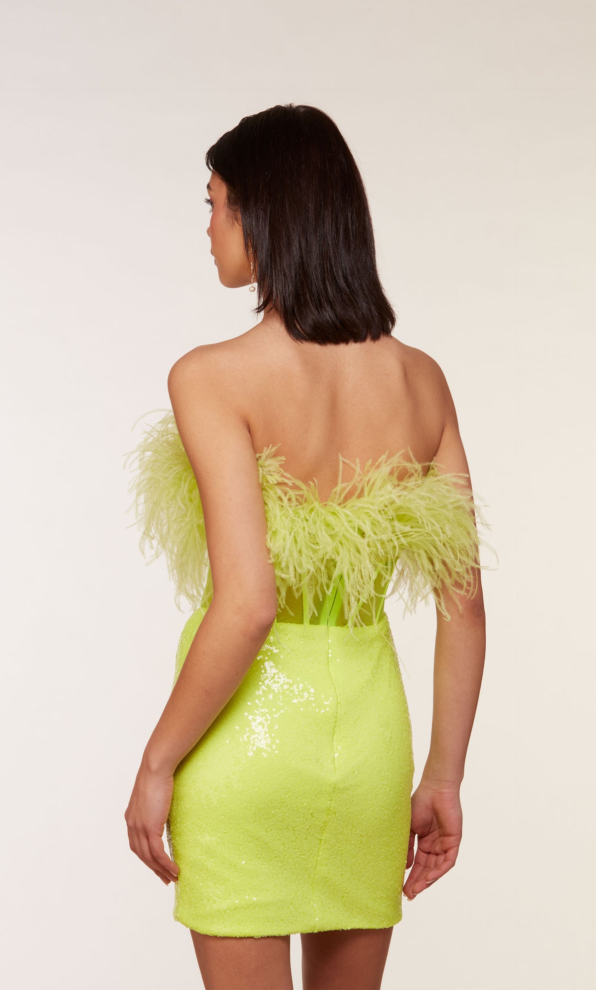 A chic, feather dress with a strapless corset bodice with a zip-up back and fitted sequin skirt in neon yellow.