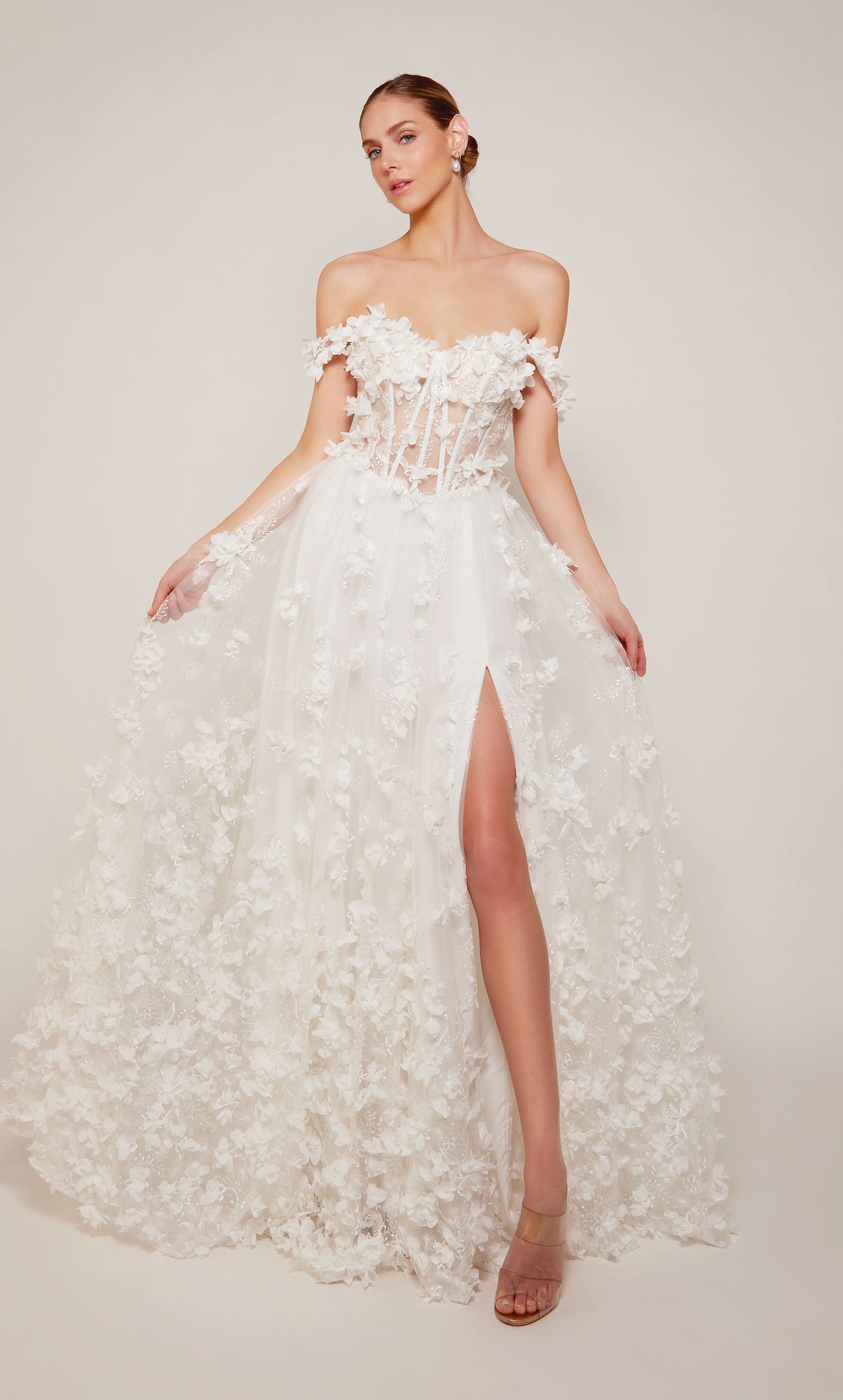 Ivory off the shoulder corset prom dress with an sheer lace up bodice and delicate 3d flowers throughout.