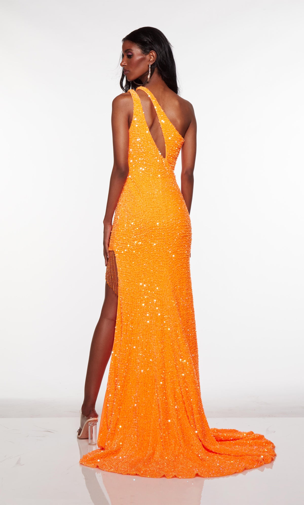 Orange one shoulder prom dress with cutout, high slit with fringe detail, and train.