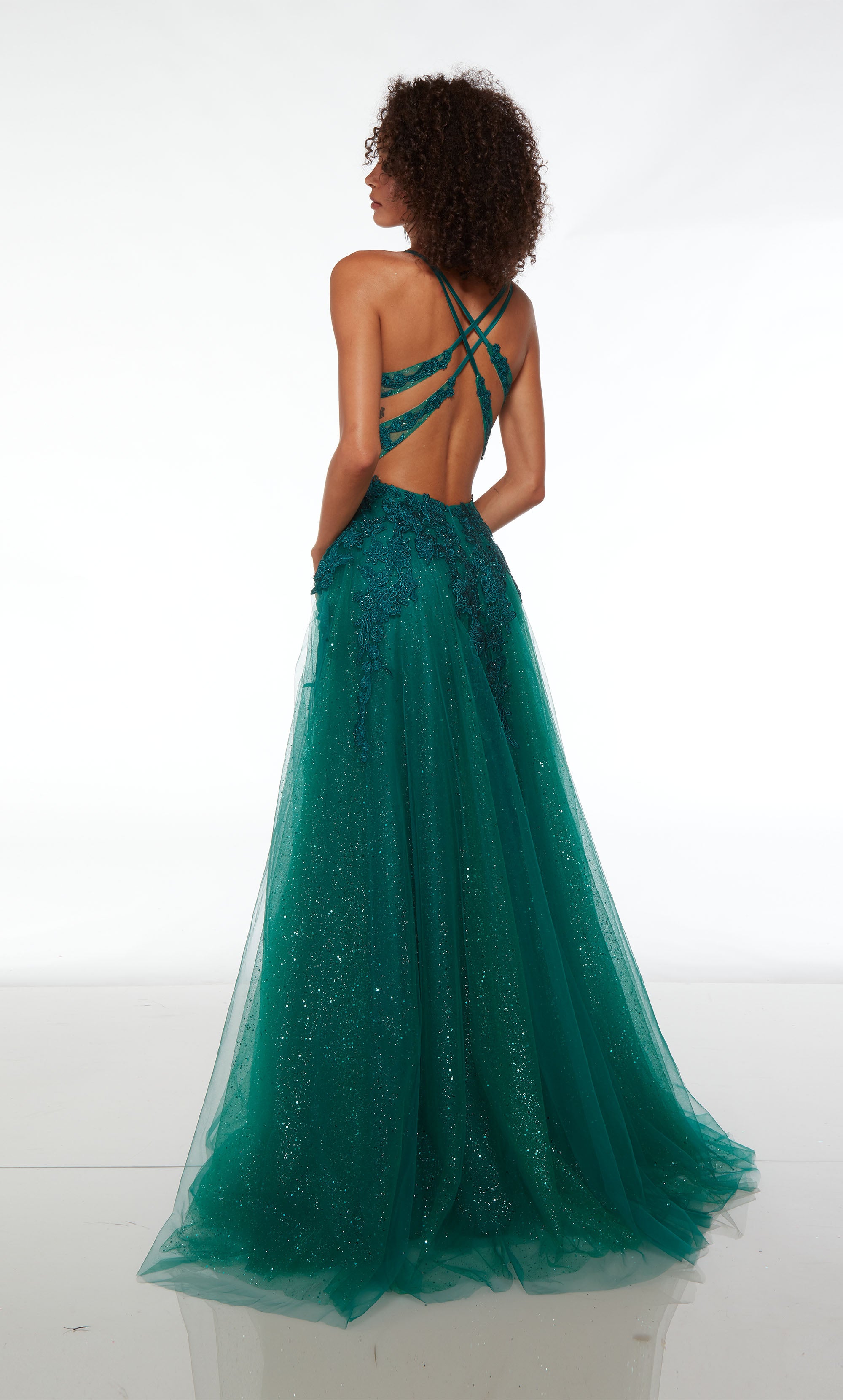Green prom dress: Plunging corset top, high slit, crisscross strappy back, and train in glitter tulle fabric. Floral lace appliques strategically placed for the perfect touch.