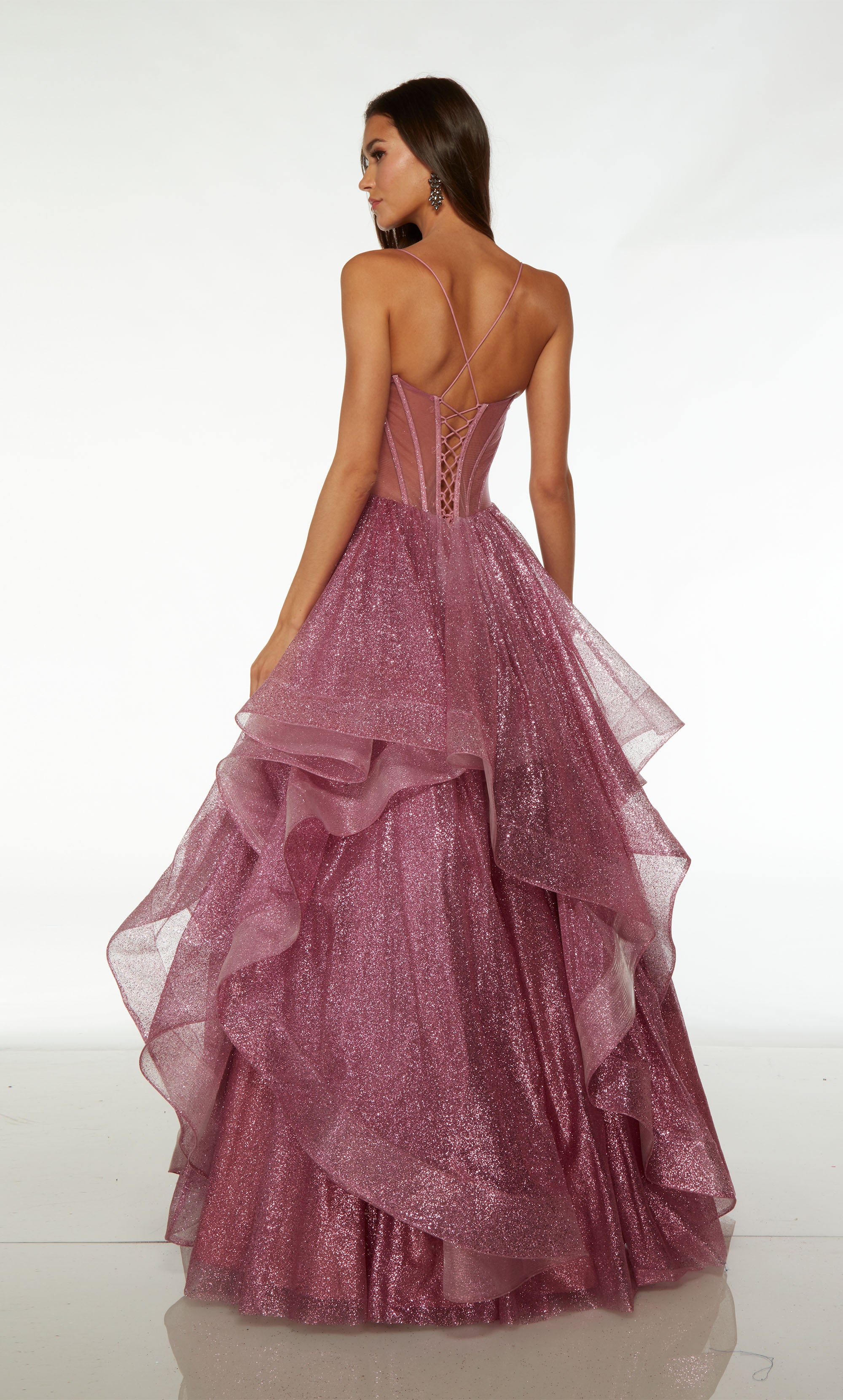 Elegant pink corset ball gown with an hand-beaded sheer bodice and an ruffled skirt in glitter tulle fabric for an glamorous and enchanting look.