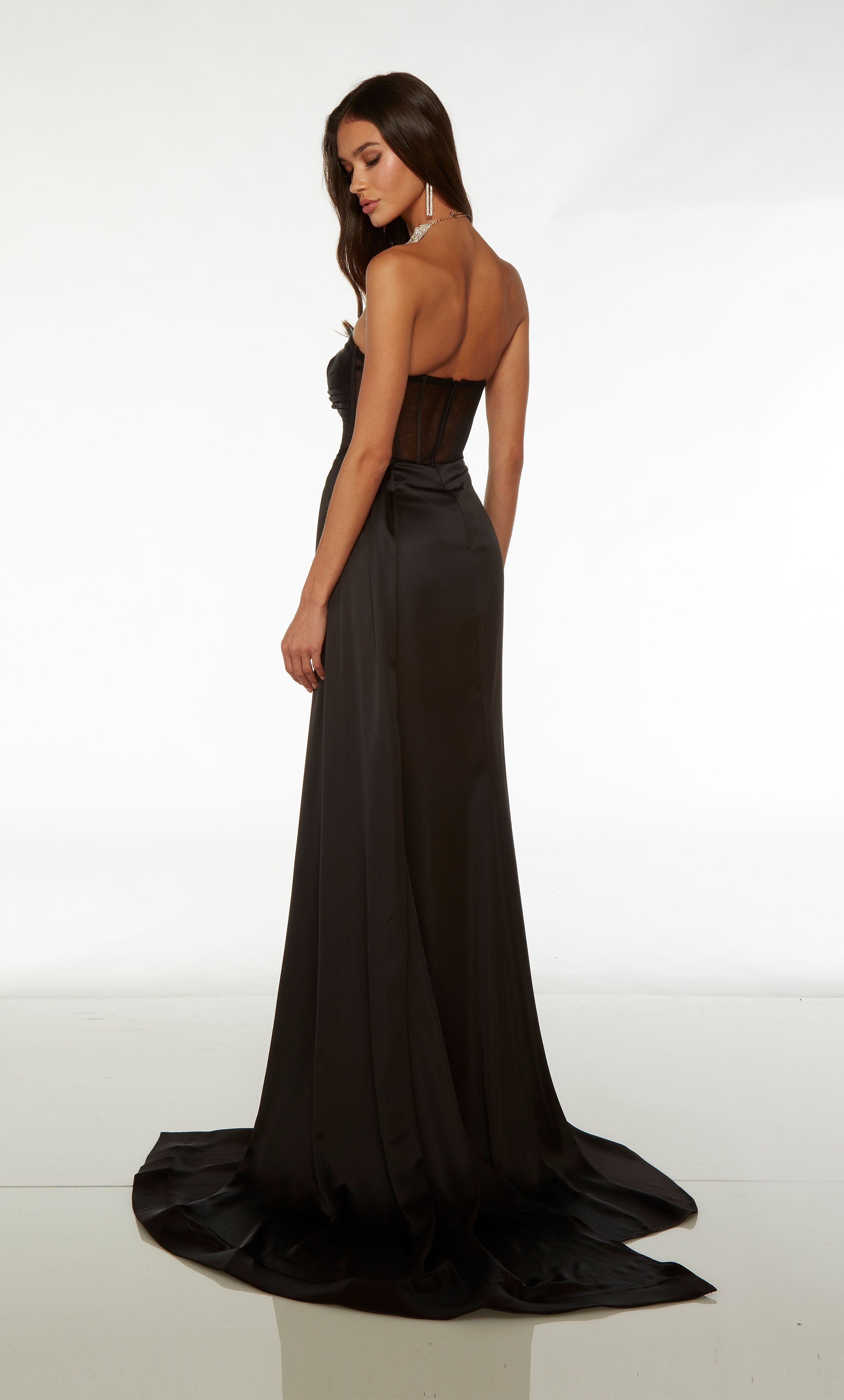 Edgy black prom dress with strapless neckline, sheer corset bodice, high side slit, train, and an detachable side train for added dramatic effect.