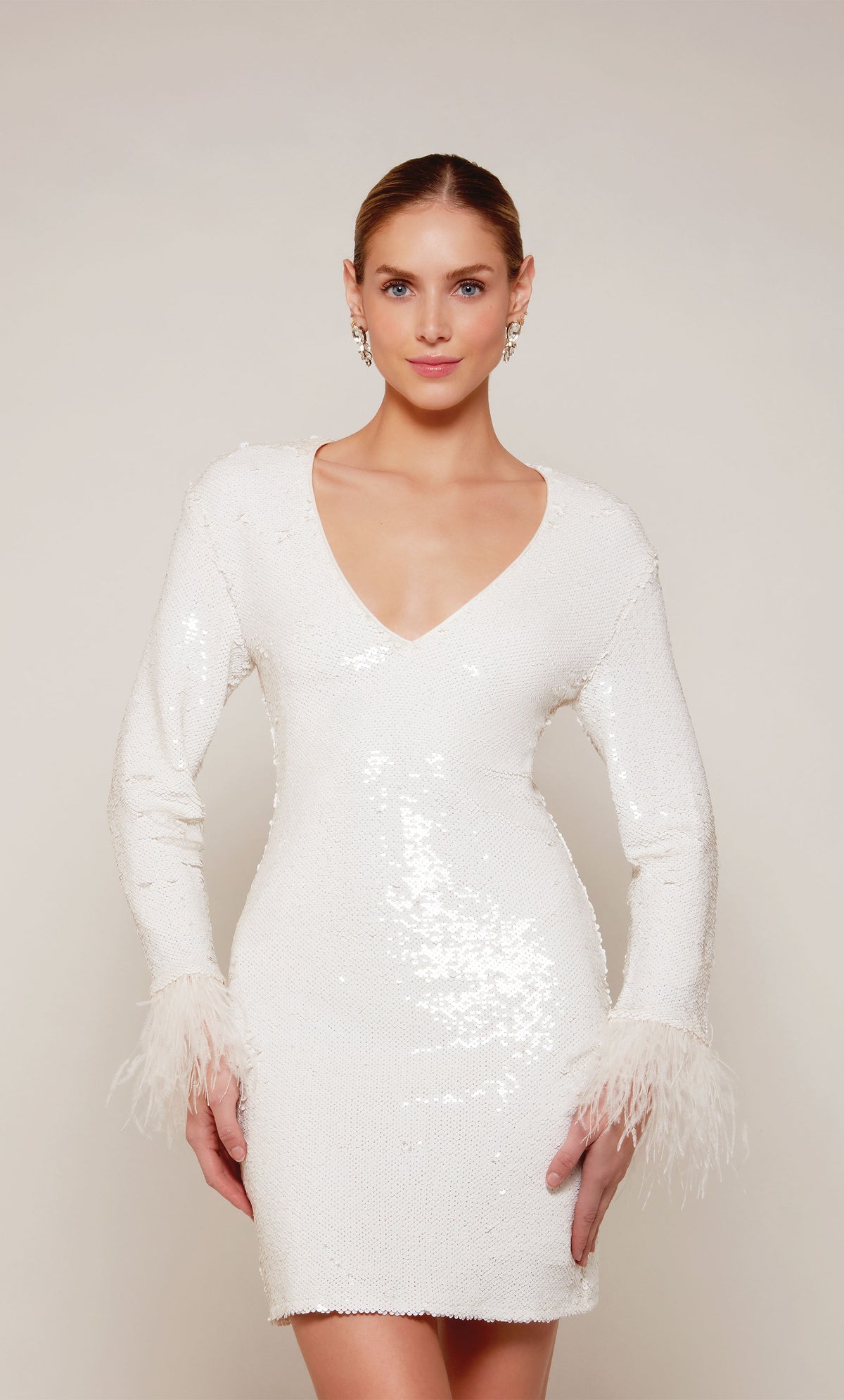 A short, long sleeve cocktail dress with feather trimmed sleeves and a V-neckline in ivory sequins.