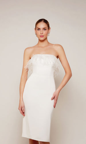 A strapless, knee length cocktail dress with feather trim in ivory.