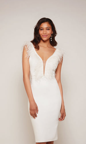 A chic, knee length cocktail dress with a plunging neckline and feather trim in diamond white.