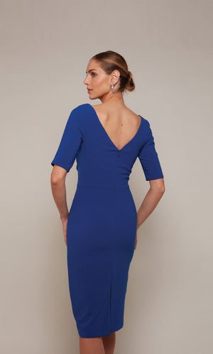 A fitted, knee length cocktail dress with a V-shaped back and 3/4 sleeves in sapphire blue.