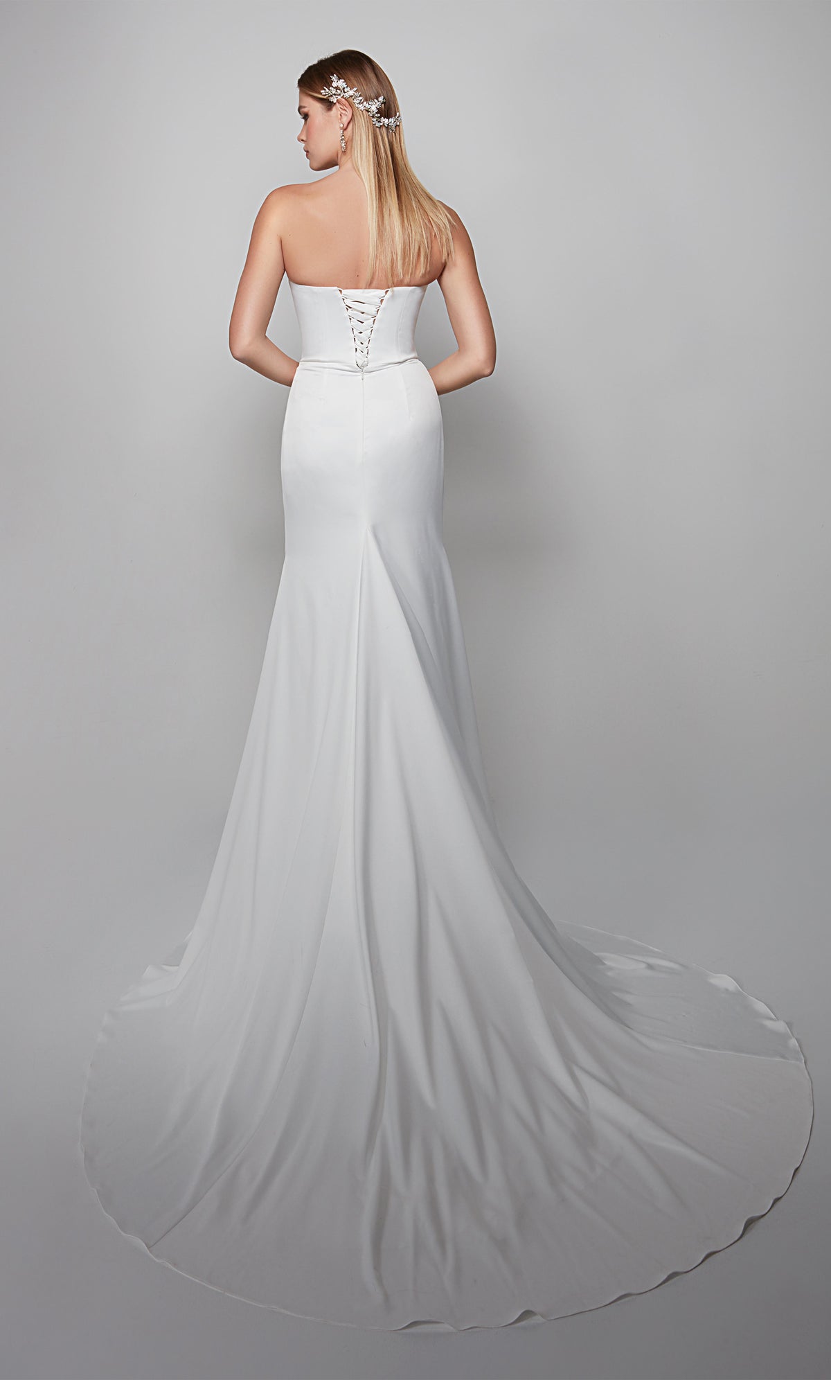 White satin wedding gown with a lace up back, removable puff sleeves, and train.