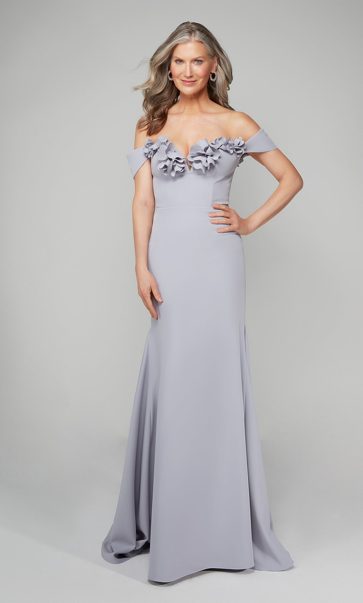 Ice blue fit and flare formal gown featuring an off the shoulder bodice enhanced with a beautiful flower volant. Color-SWATCH_7062__DIAMOND-WHITE