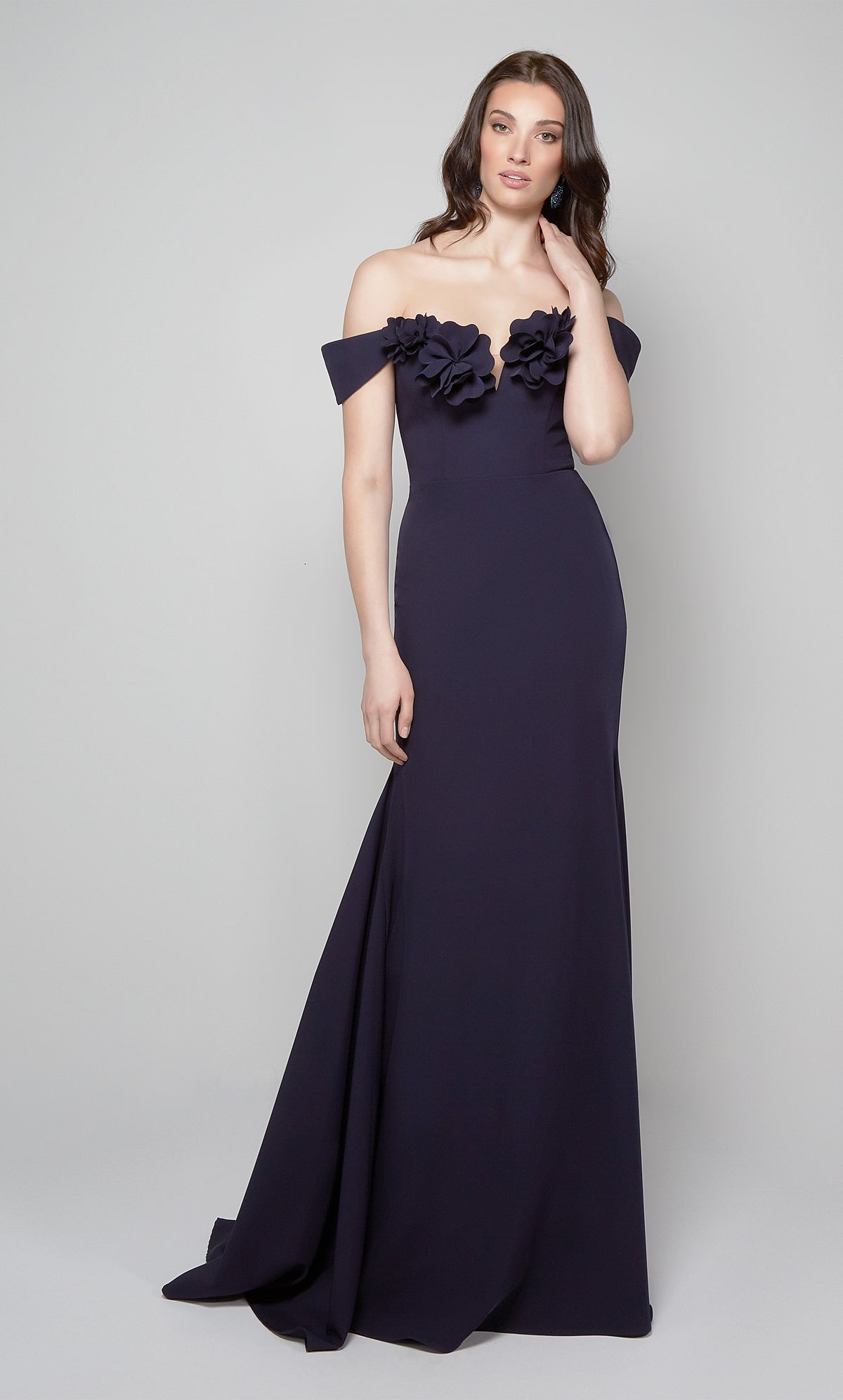 Midnight blue fit and flare evening dress featuring an off the shoulder bodice enhanced with a beautiful flower volant.