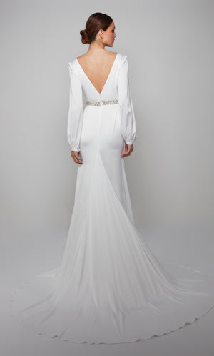 Plunging long sleeve wedding gown enhanced with a deep V back, faux belt at the natural waist, and gorgeous train.