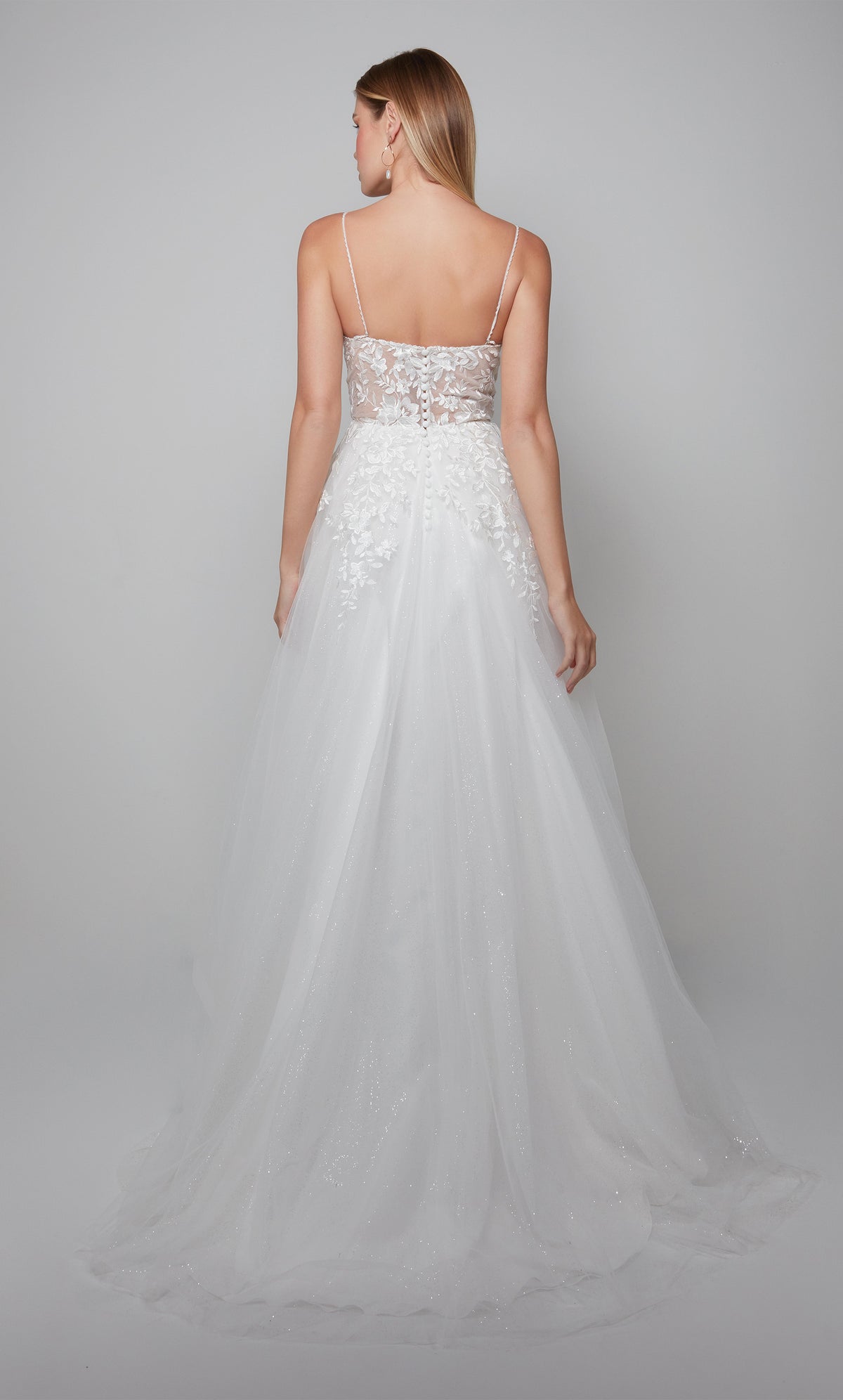 Classic tulle wedding gown with a sheer lace bodice, satin buttons, and train in ivory.