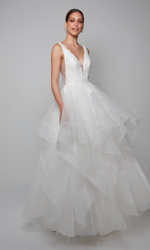 Tulle wedding gown with a plunging lace bodice, tiered skirt, and floral lace appliques in ivory.