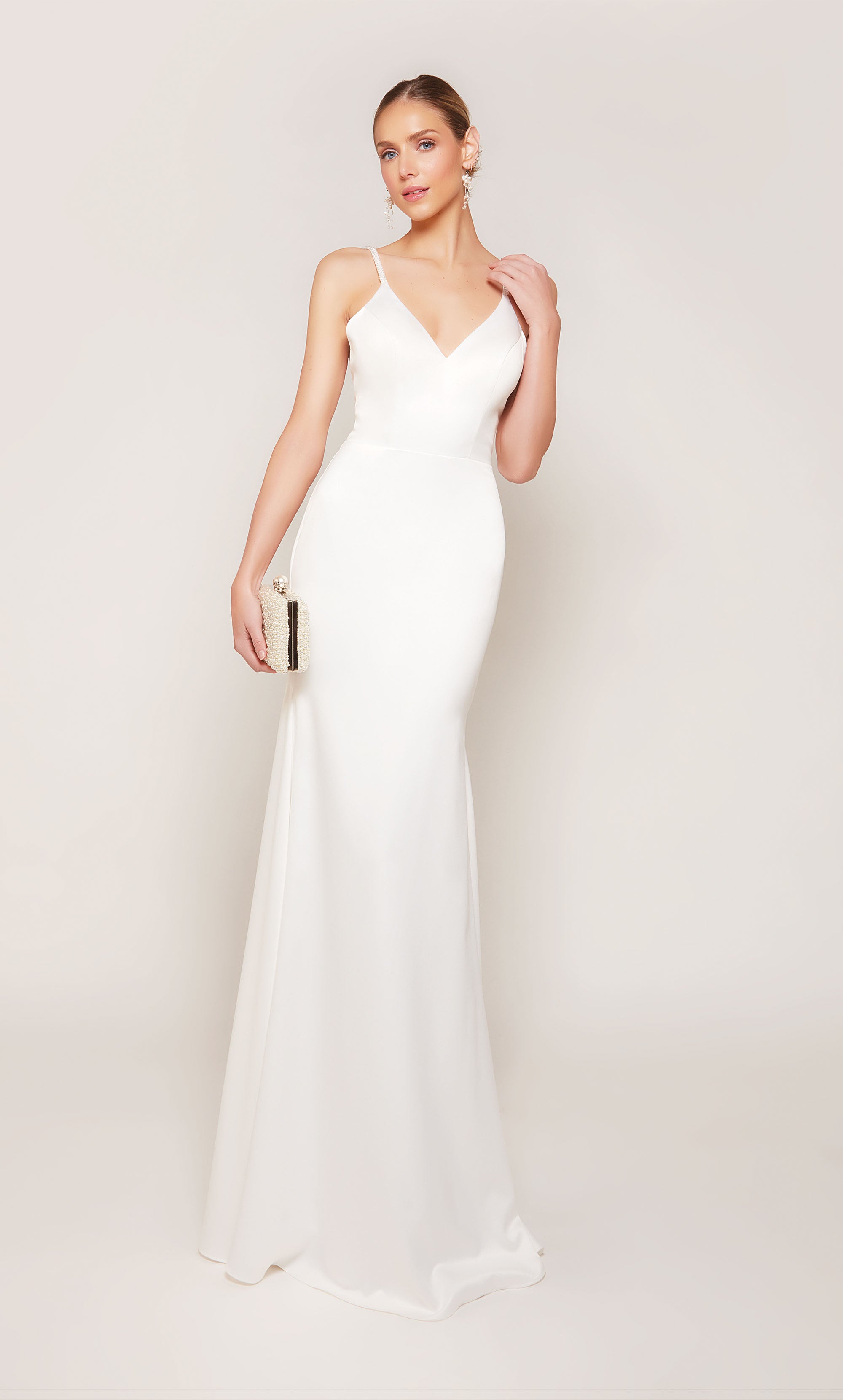 Simple and chic satin wedding dress with a V-neckline and thin spaghetti straps. The dress comes with a detachable train that adds a hint of drama and formality during the ceremony, and can be detached for a more understated reception style.