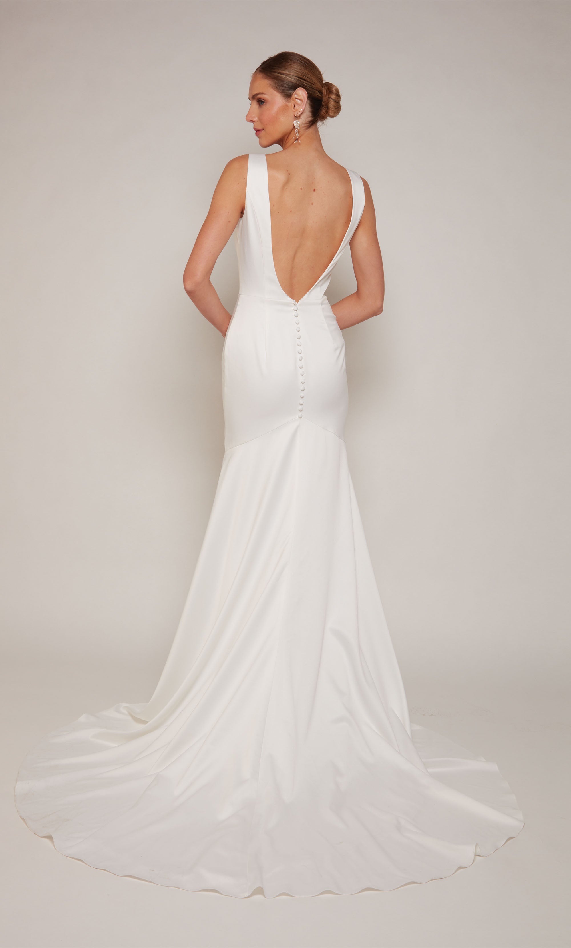 A white, satin wedding gown with an illusion deep V-neckline and elegant side slit.