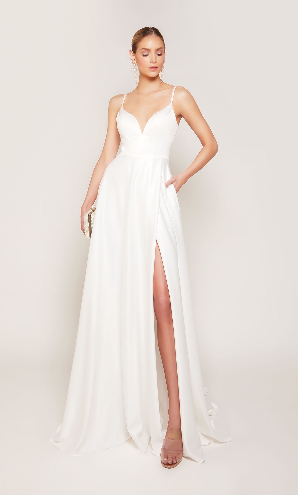A simple, satin wedding dress with a V-neckline, side slit, and pockets. 