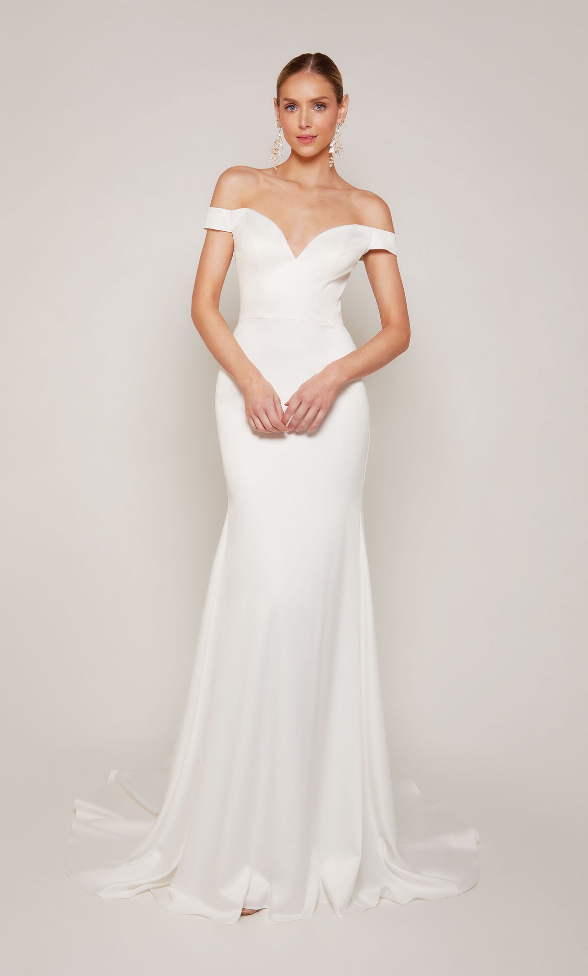 A sophisticated, off-the-shoulder satin wedding dress with a detachable train and satin-covered buttons 