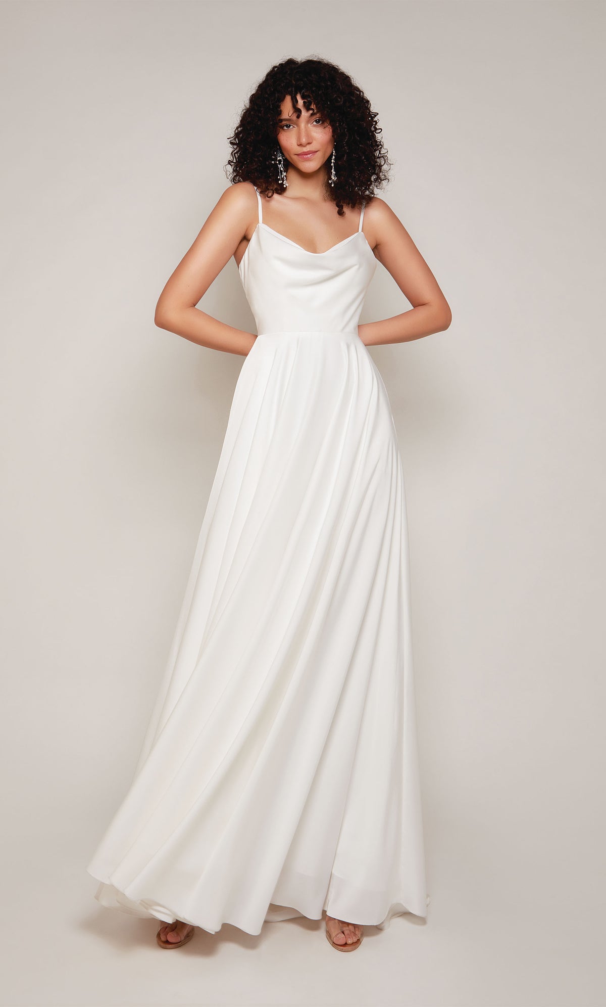 A simple wedding dress in white satin with an A-line skirt, V-shaped cowl neckline, and adjustable spaghetti straps.